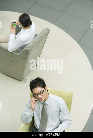 Executive using cell phone in lobby Stock Photo