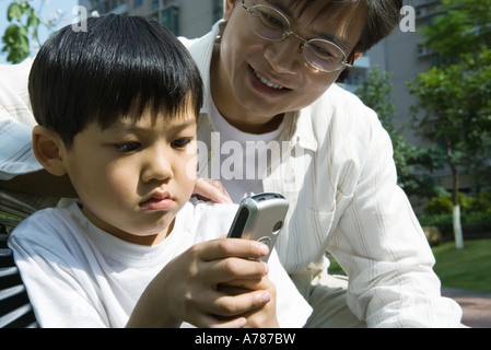 Father and son, boy looking at cell phone Stock Photo