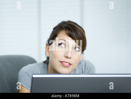 Young woman on couch, using laptop Stock Photo