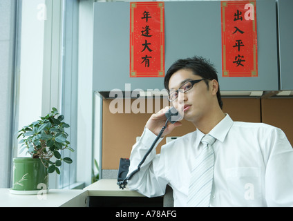 Businessman using phone in office Stock Photo