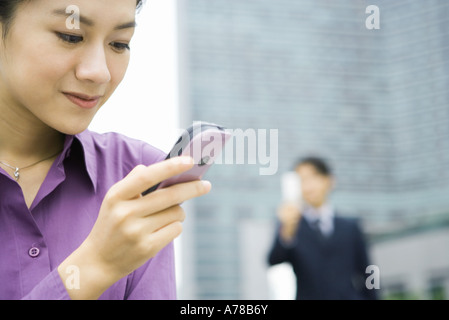 Businesswoman using messaging phone, close-up Stock Photo