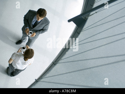 Male and female associates having coffee, full length, high angle view Stock Photo