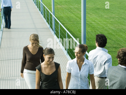 Young professionals walking and standing on walkway Stock Photo