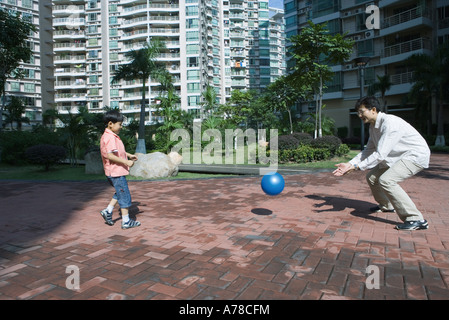 Father and son playing ball in apartment complex Stock Photo