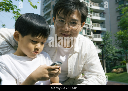 Boy and father, boy using cell phone Stock Photo