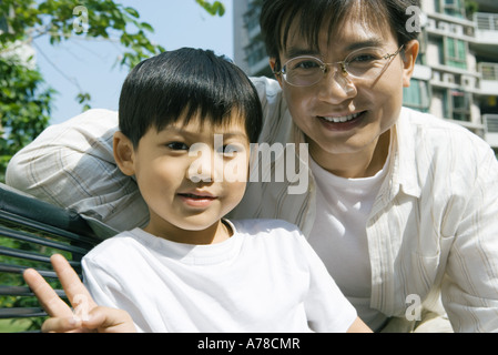 Father and son, boy making 'v' sign with fingers Stock Photo