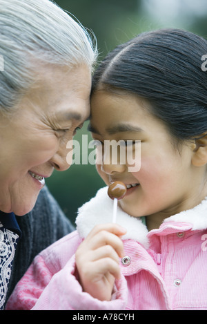 Girl with grandmother, eating lollipop Stock Photo