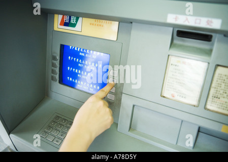 Person using ATM machine, cropped view Stock Photo