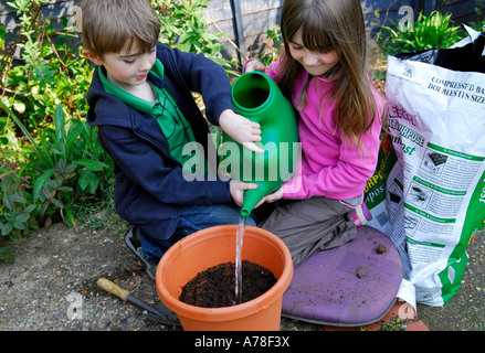 children watering seeds in garden Stock Photo
