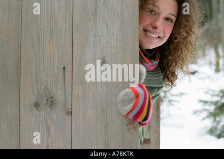 Woman hiding behind a fence Stock Photo