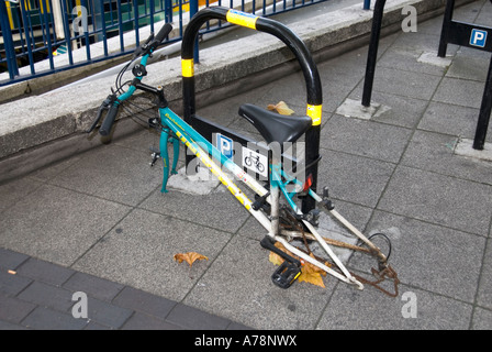 Elephant and Castle area of South London remains of vandalised bike with only main frame padlocked to official parking place Stock Photo