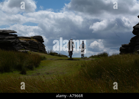 Mountain Bike riders ride a singletrack path on Dartmoor. Stock Photo