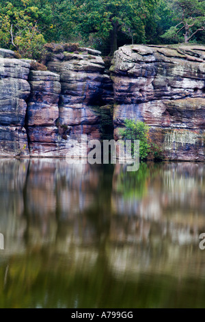 Millstone grit rocks reflected in the lake at Plumpton Rocks near Knaresborough North Yorkshire England Stock Photo