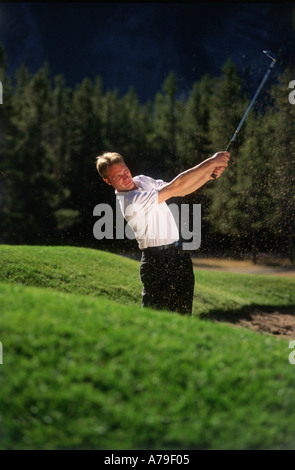 Male golfer chipping ball from the sand Stock Photo