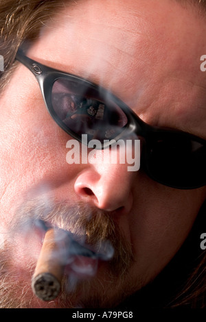 Gambler smoking cigar with Texas holdem game reflected in sunglasses Stock Photo