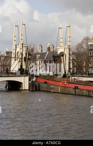 Boat passing open White Skinny Bridge or Magere Brug on Amstel River, Amsterdam Holland Stock Photo