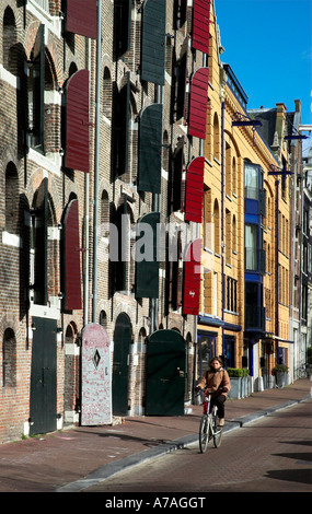 A residential street in Amsterdam, with the tall narrow buildings with their shutters open Stock Photo