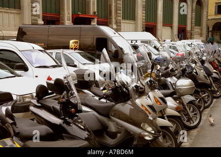 UPS delivery truck snuggles into parking place among motorcycles in parking lot in Florence Italy Stock Photo