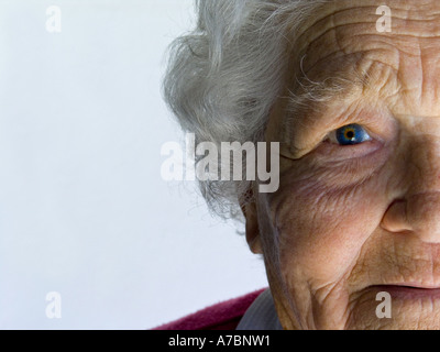 ELDERLY FACE SMILING 90 years age Close up half face portrait of contented alert smiling elderly old lady on white background Stock Photo