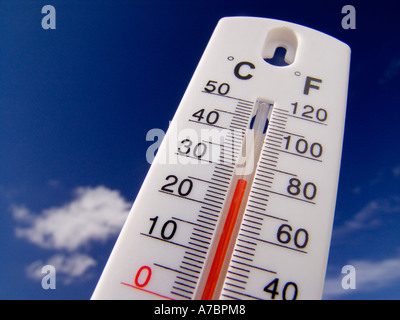 HEATWAVE Temperature rising Concept Thermometer displays a hot and sunny 28 degrees centigrade ( 82F) against a bright blue sky Stock Photo