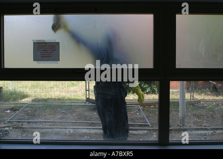 Workman cleaning the window frames outside the nursery Stock Photo