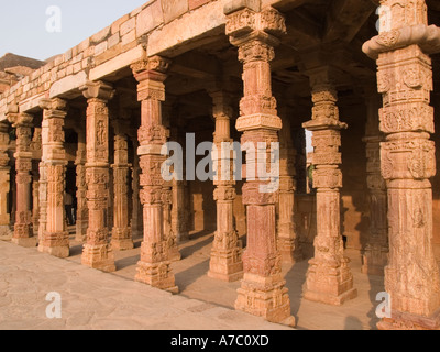 Carved pillars in cloisters of Quwwat UI Islam Mosque in the Qutb Minar complex. Delhi India Asia Stock Photo