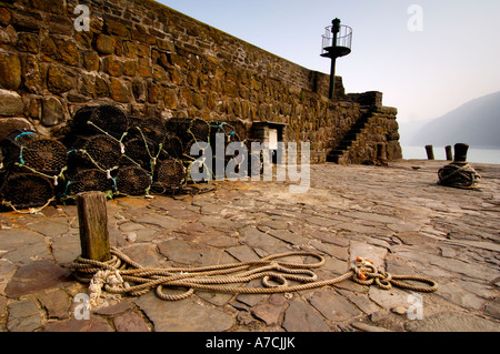 Lobster pots on the end of the historic 14th century stone built harbour at Clovelly North Devon Stock Photo