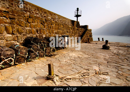 Lobster pots on the end of the historic 14th century stone built harbour at Clovelly North Devon Stock Photo