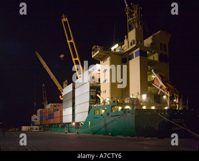 A modern dark green container ship moored at dockside at night in the Port of Caldera Costa Rica Republic Central America Stock Photo