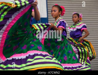 Three attractive local young girl folk dancers perform with swirling dancer’s dresses in Corinto Nicaragua Central America Stock Photo