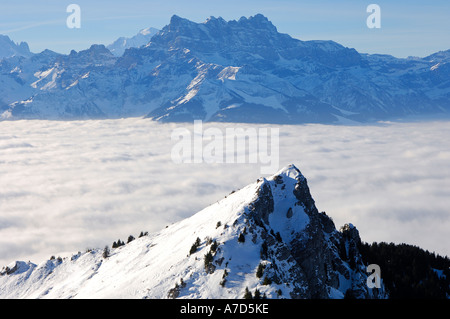 View across the clouds hanging over Lac Lemantowards Dents du Midi with Haute Cime 3257 m Valais Switzerland Stock Photo