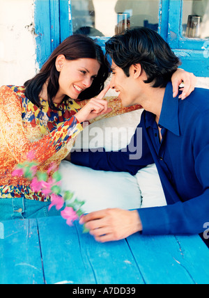 couple sitting at blue table outdoors Stock Photo