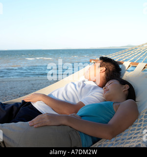 Couple in hammock on beach Stock Photo
