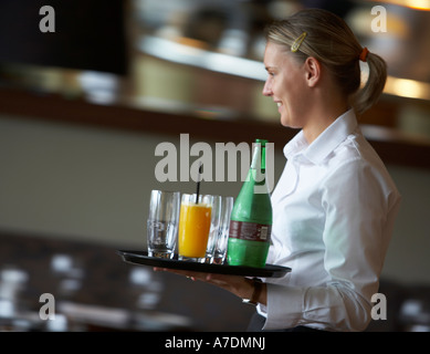 Waitress carrying tray of drinks in a restaurant service Stock Photo