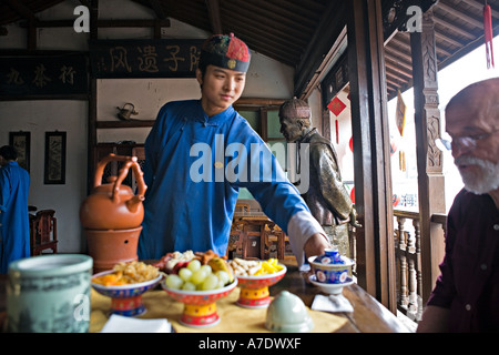 https://l450v.alamy.com/450v/a7dwxf/china-hangzhou-young-tea-server-pours-tea-for-western-tourist-a7dwxf.jpg