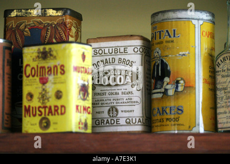 Antique tins on a parlour shelf Stock Photo