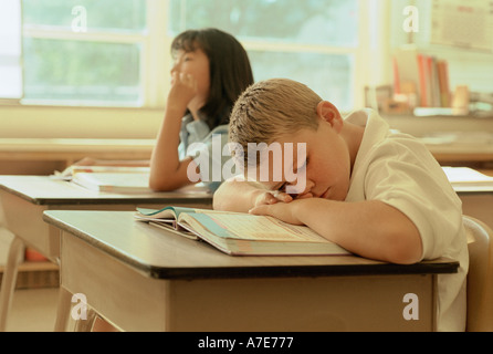 Boy sleeping in school classroom Stock Photo