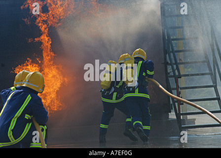Fire recruits tackle a simulated blaze as part of their passing out ceremony UK Stock Photo