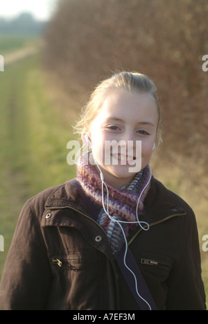 12 year old girl takes a countryside walk near Pirton in Hertfordshire whilst listening to her MP3 player UK Stock Photo