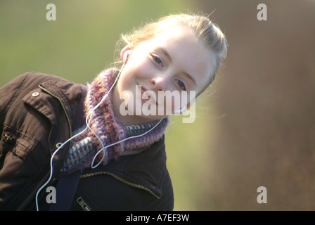 12 year old girl takes a countryside walk near Pirton in Hertfordshire whilst listening to her MP3 player UK Stock Photo