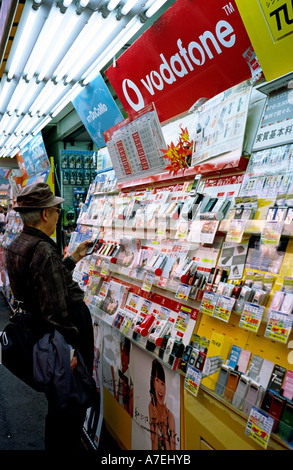 Nov 09, 2004 - Customer looking at mobile phones outside a shop in Akihabara (Electric Town) in the Japanese capital of Tokyo. Stock Photo