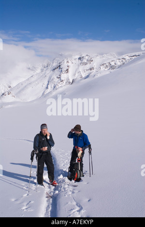 Two skiers applying sunscreen while skinning up the Asulkan Glacier, Rogers Pass, Selkirk Mountains, Canadian Rockies, Canada Stock Photo