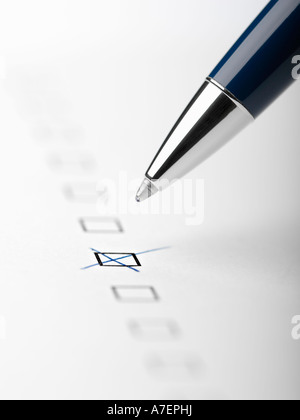 Pen writing X in checkbox close up crop Stock Photo