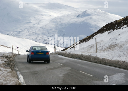 A car travelling through snow-covered - Cairnwell Spittal of Glenshee summit or Devil's Elbow A93 Braemar, Aberdeenshire in winter snows, Scotland, UK Stock Photo