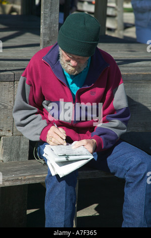 man doing newspaper crossword puzzle on bench near Stock Yards in Ft Worth Texas Stock Photo