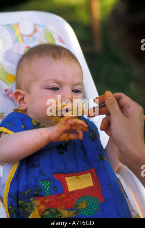 Detroit Michigan Mariel West six months old makes a mess as she eats lunch Stock Photo