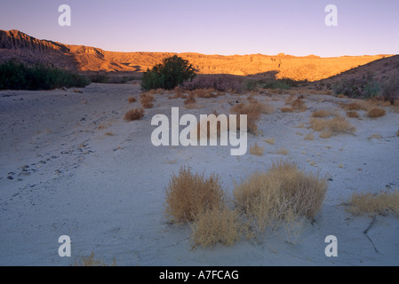Sunrise colors the canyon walls above the dry Mojave River in Afton Canyon, California, USA Stock Photo