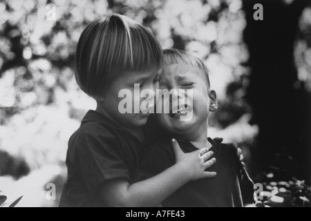 Big sister comforts and embraces her little brother to alleviate fears and anxieties Stock Photo
