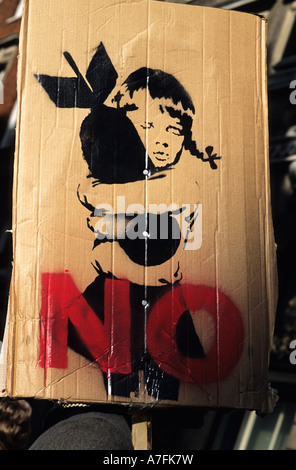 Stop the war demonstration Placard featuring stenciled drawing by Banksy of a young girl clutching a bomb Stock Photo