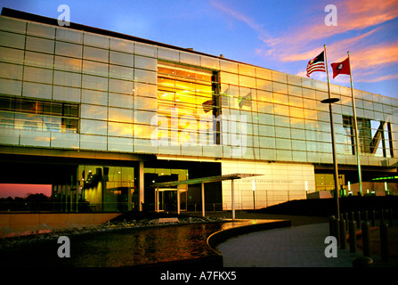 A beautiful sunset and the United States and Arkansas flags reflect in the glass of the William Jefferson Clinton Library Stock Photo